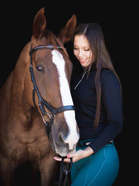 Woman with chestnut horse. Black long sleeve riding top and juniper riding tights