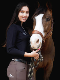 Woman with horse. Woman wearing long sleeve riding top in black