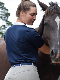 Woman with horse, showing back of riding shirt