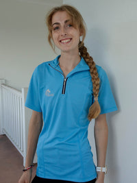 Smiling woman wearing sky blue riding top