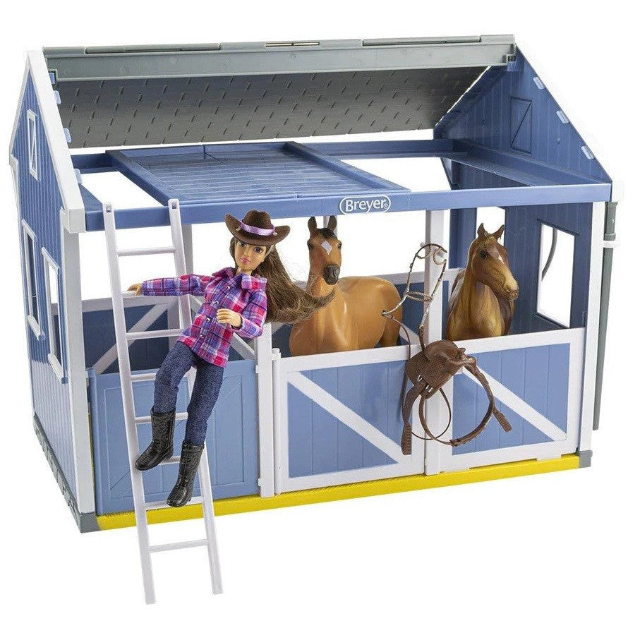 Breyer Horse Toys stable with doll, two horses, and equestrian accessories.