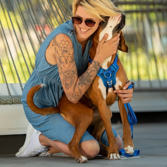 Woman hugging dog wearing Rogz harness and leash.