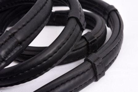 Close-up of Thinline black leather reins, coiled and stitched.